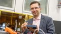 Dmitry shown wearing safety glasses and testing a battery with electronic equipment.